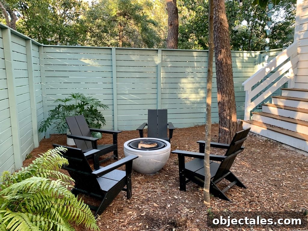 Create a Cozy Fire Pit Area for Outdoor Gatherings 11 Painted fenced side yard with black Adirondack chairs around fire pit with potted plants