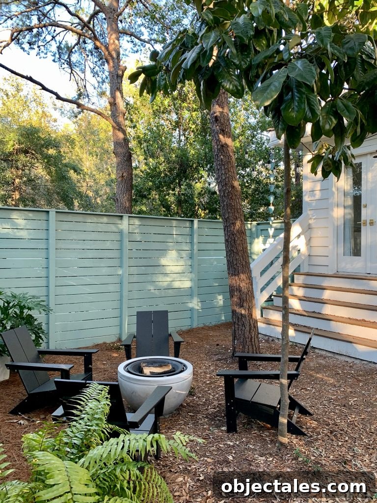 Create a Cozy Fire Pit Area for Outdoor Gatherings 12 Trees around fenced side yard with black Adirondack chairs around fire pit