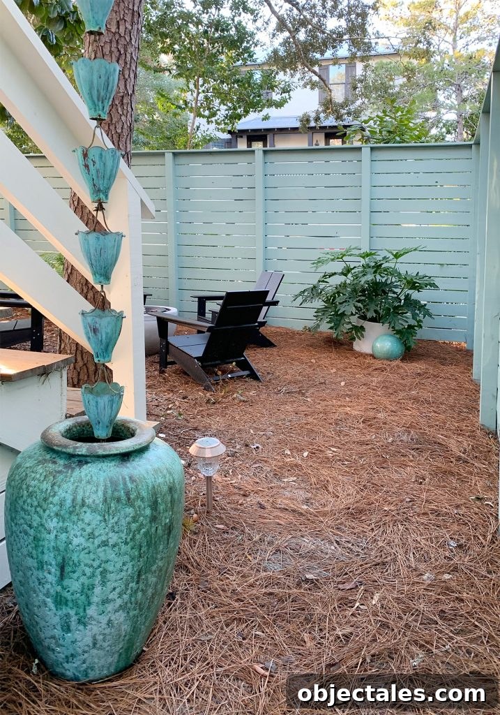 Create a Cozy Fire Pit Area for Outdoor Gatherings 14 View through gate fence next to blue-green pot and rain chain