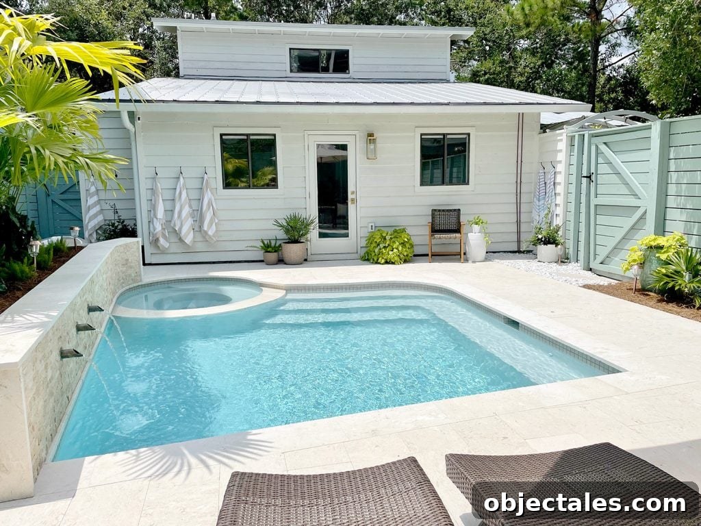 Small freeform pool with white house metal roof in background