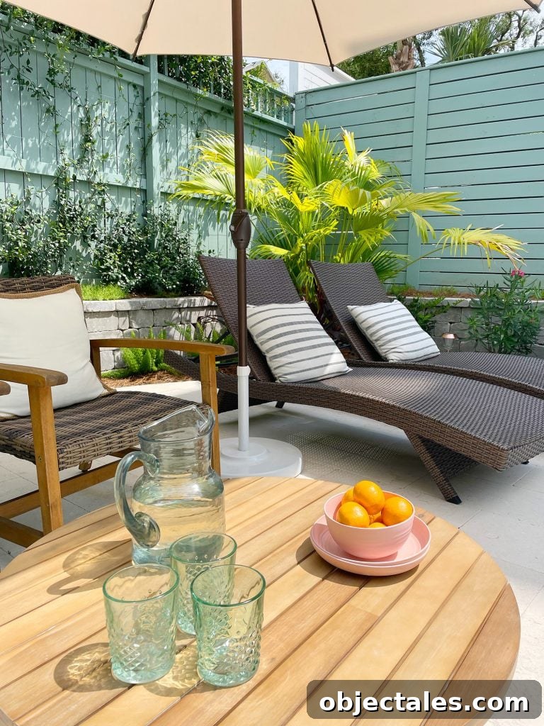 Pool patio area with brown chairs and wicker lounge chairs under umbrella