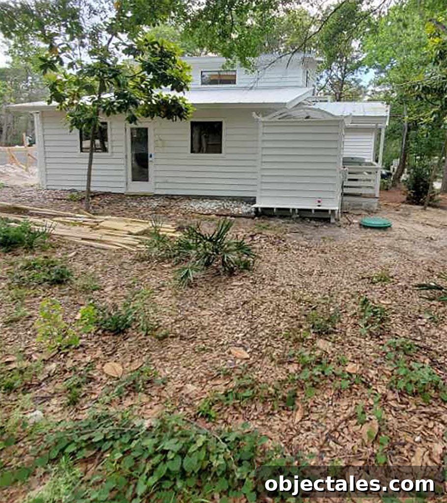 Before photo of white house with dirt and weedy yard