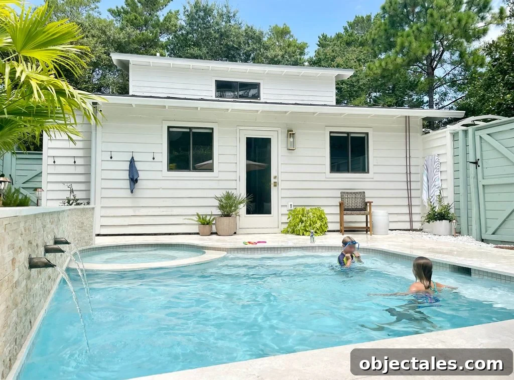 Two kids playing in small freeform pool with scupper fountains on wall