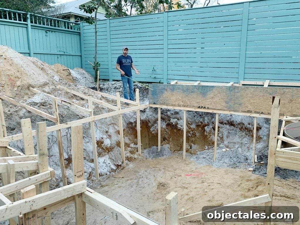 John standing next to frame pool hole during backyard Florida pool construction