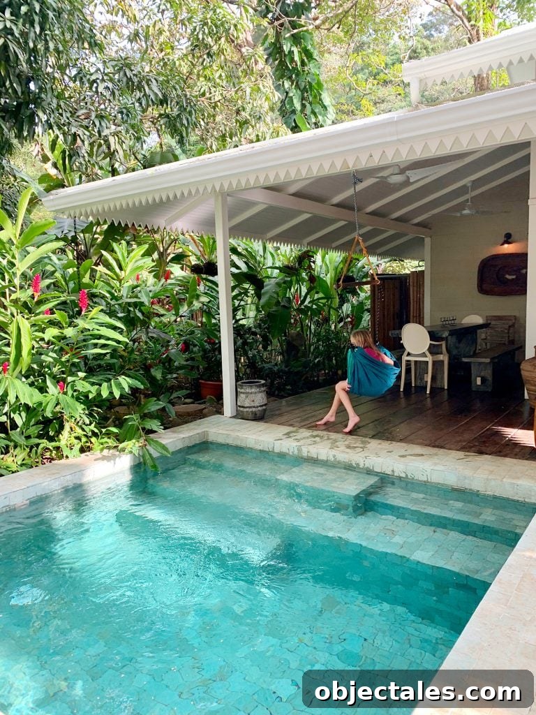 Inspiration photo of small tropical pool next to white house and child in swing