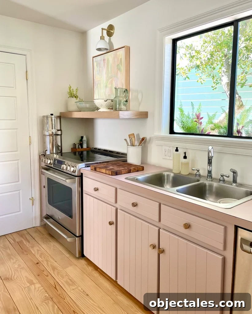 Beachy Kitchen With Mauve Pink Cabinets And Wood Floating Shelves With Mid Century Modern Lights