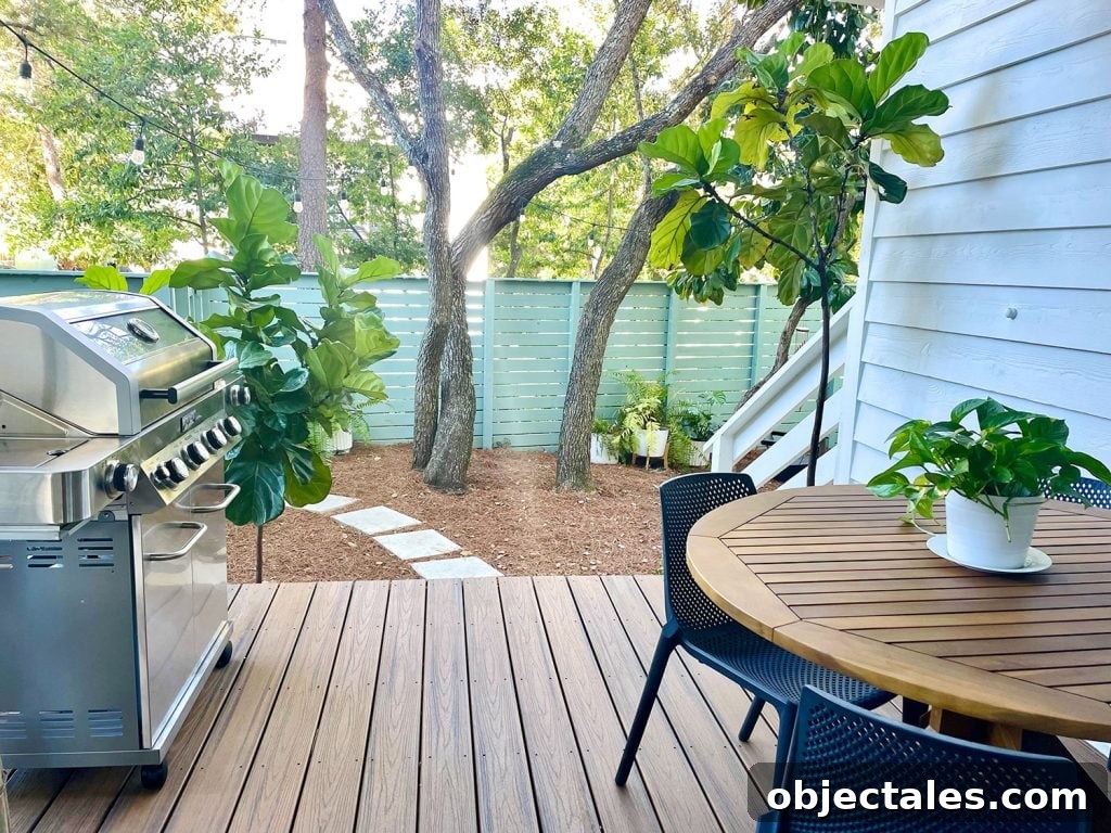 View from cover patio with grill and table overlooking greenery in yard