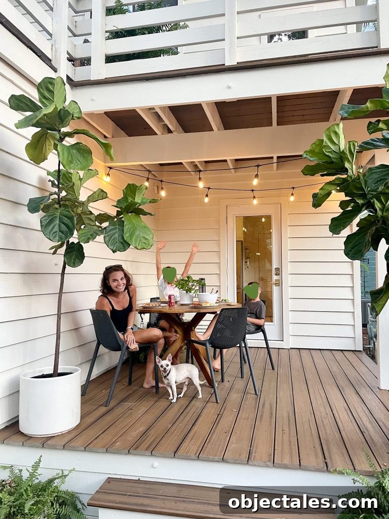 Family eating outside on covered porch with string lights on and chihuahua under table